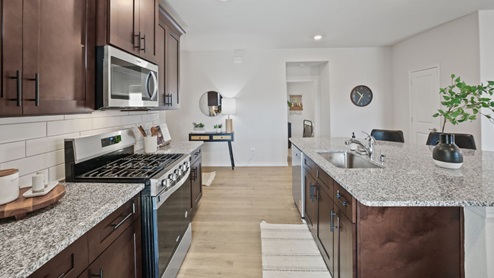 kitchen with brown cabinetry, large island and stainless steel appliances