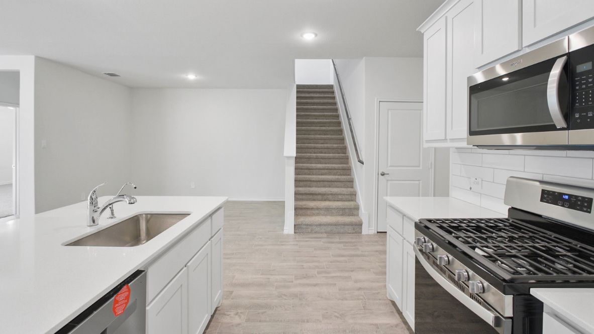 Contemporary kitchen adorned with white cabinets seamlessly integrated into an open dining area layout.