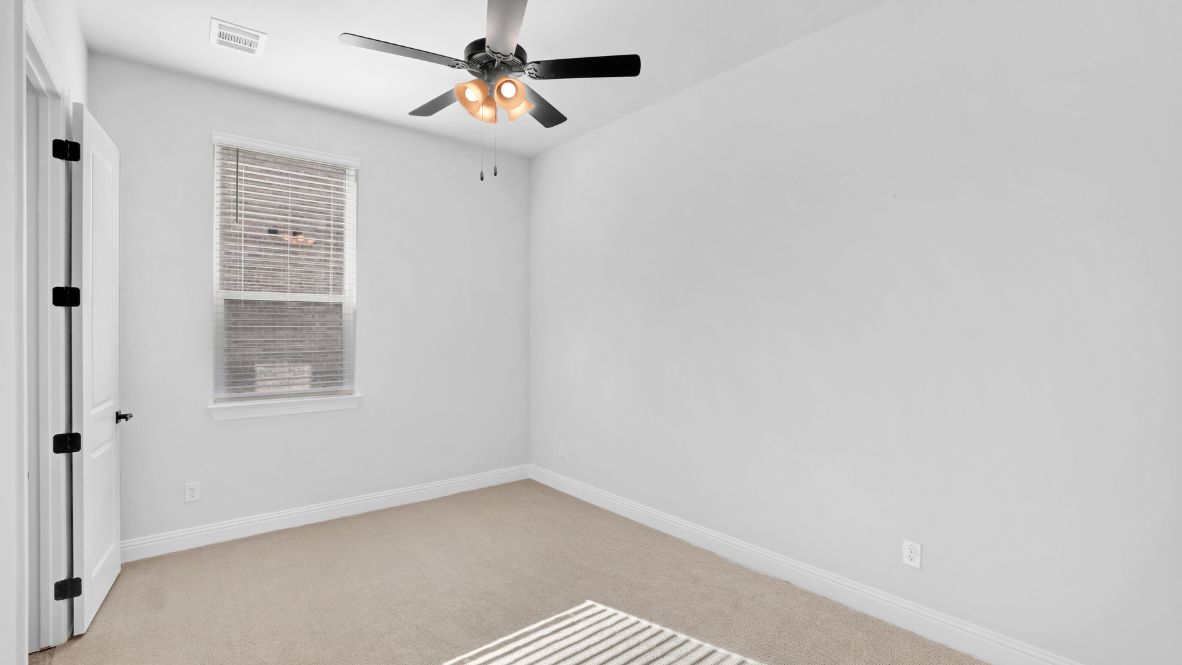 Bedroom with light brown carpet and a window.