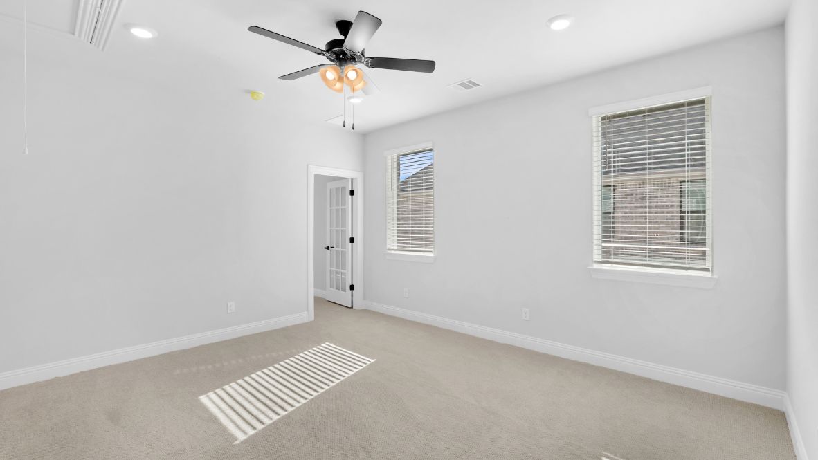 Area at the top of the stairs with light brown carpet and windows.