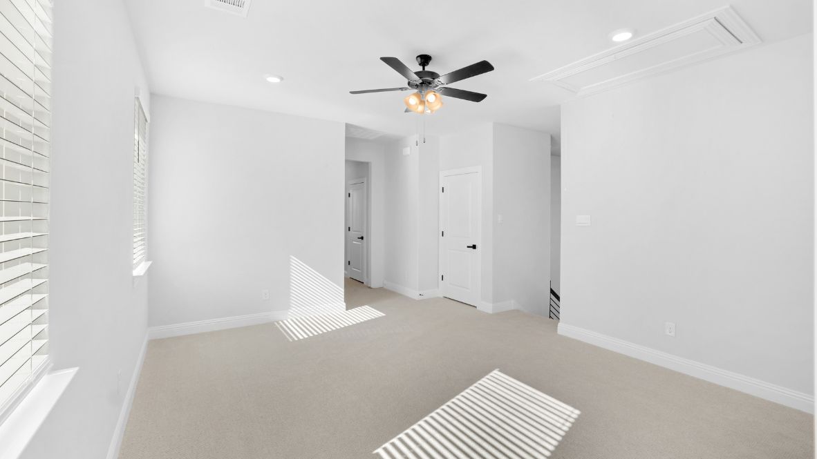 Area at the top of the stairs with light brown carpet and windows.