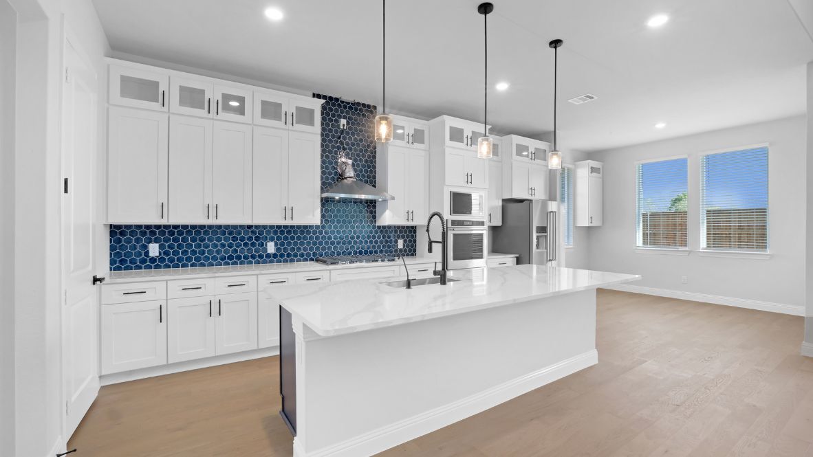 Kitchen featuring white cabinets, blue tile, and stainless steel appliances.