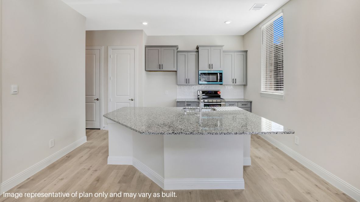 Inside, natural light floods the open-concept living space, highlighting the sleek picture-frame cabinetry, quartz or granite countertops, and stainless steel appliances in the chef-inspired kitchen.
