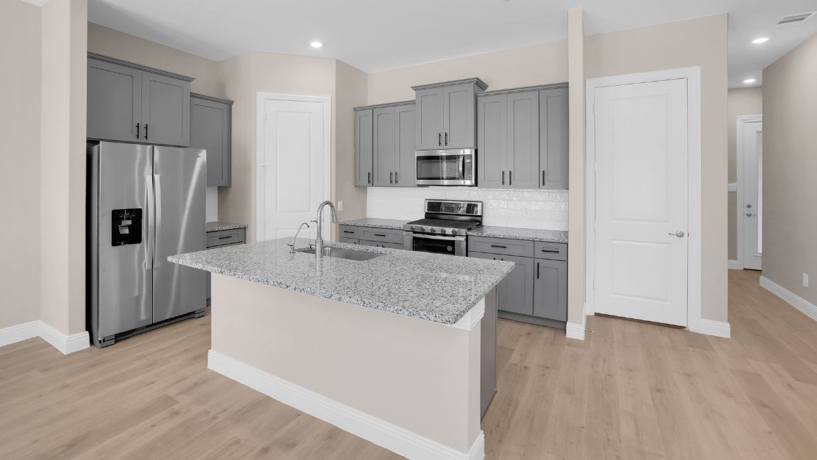 Spacious kitchen with hard surface flooring, pantry and island counterspace.