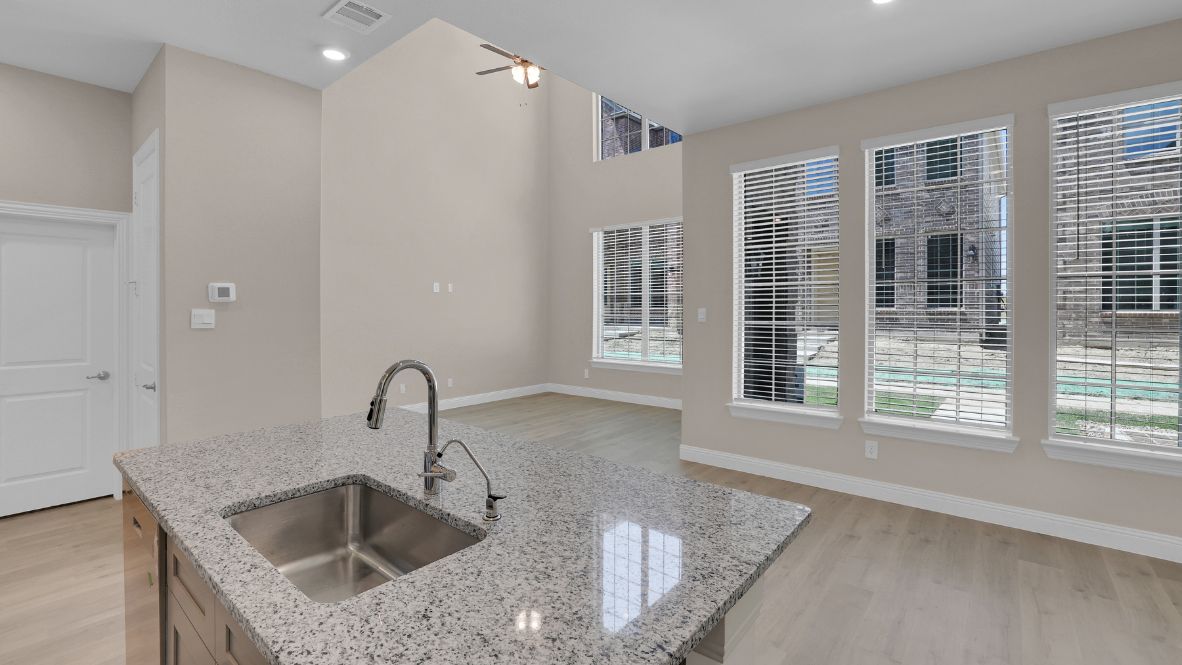 Spacious kitchen with hard surface flooring, pantry and island counterspace.