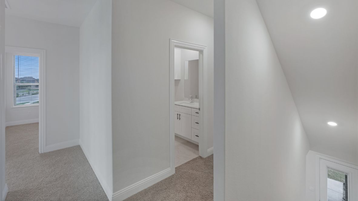 upstairs hallway view with beige carpet and white walls