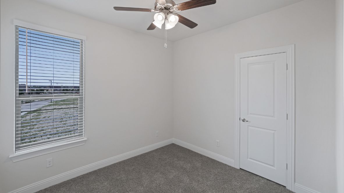 bedroom with grey carpet and white walls and a window