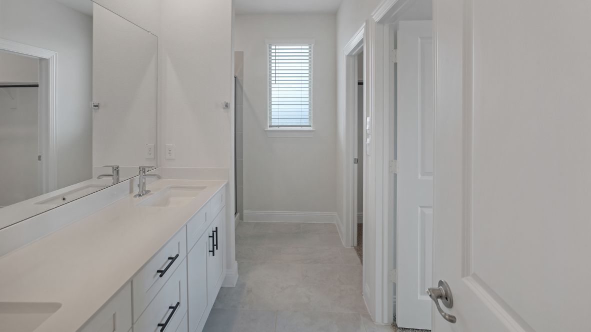 bathroom with dual vanity sinks, toilet, and a walk in shower
