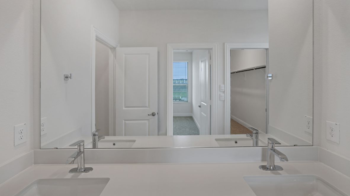 bathroom with dual vanity sinks, toilet, and a walk in shower