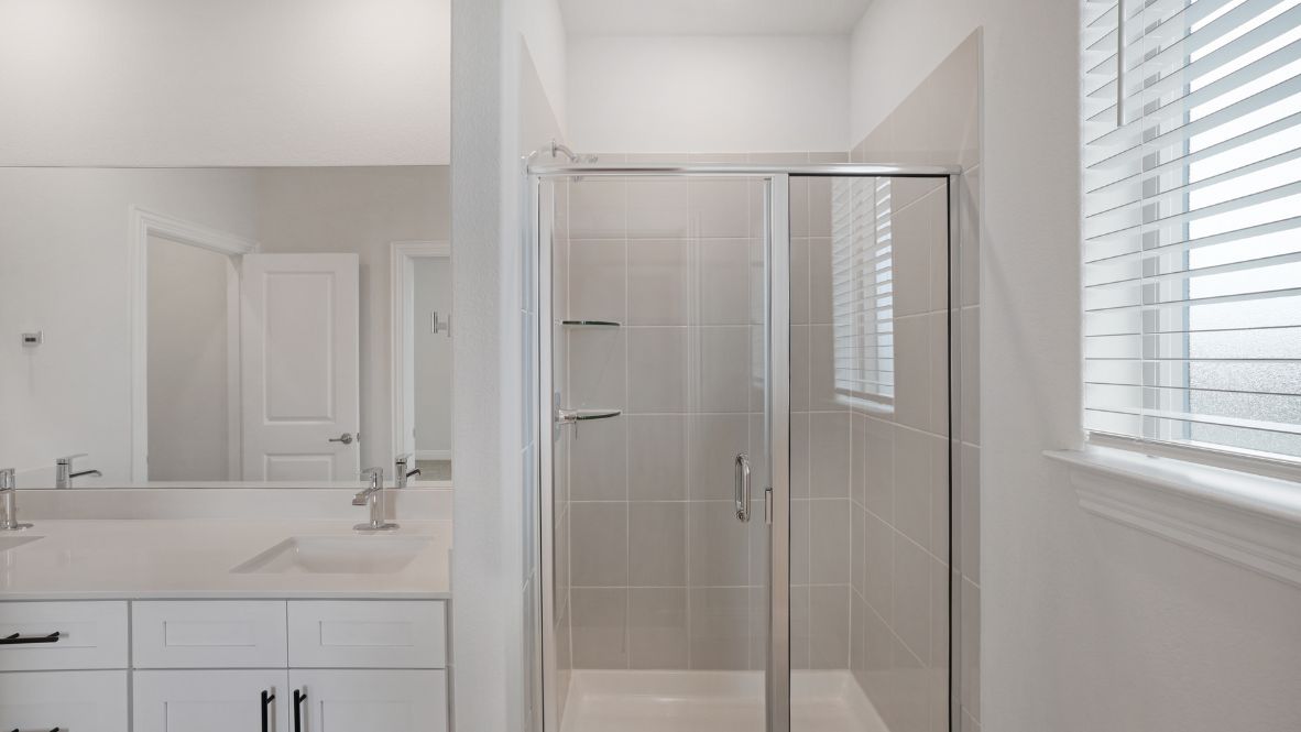 bathroom with dual vanity sinks, toilet, and a walk in shower