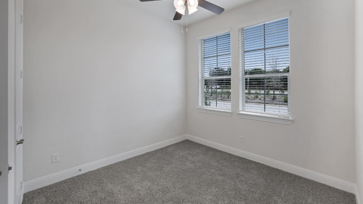 bedroom with grey carpet and white walls and a window