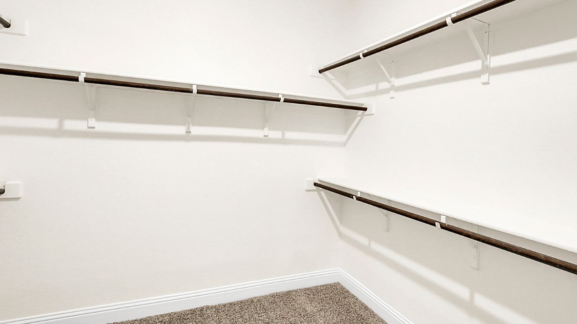 Spacious modern bathroom featuring a glass-enclosed shower, a large soaking tub with tiled surround and dual-sink vanity with sleek countertop. The layout includes a private water closet and a walk-in closet for added convenience, with natural light streaming through the window.