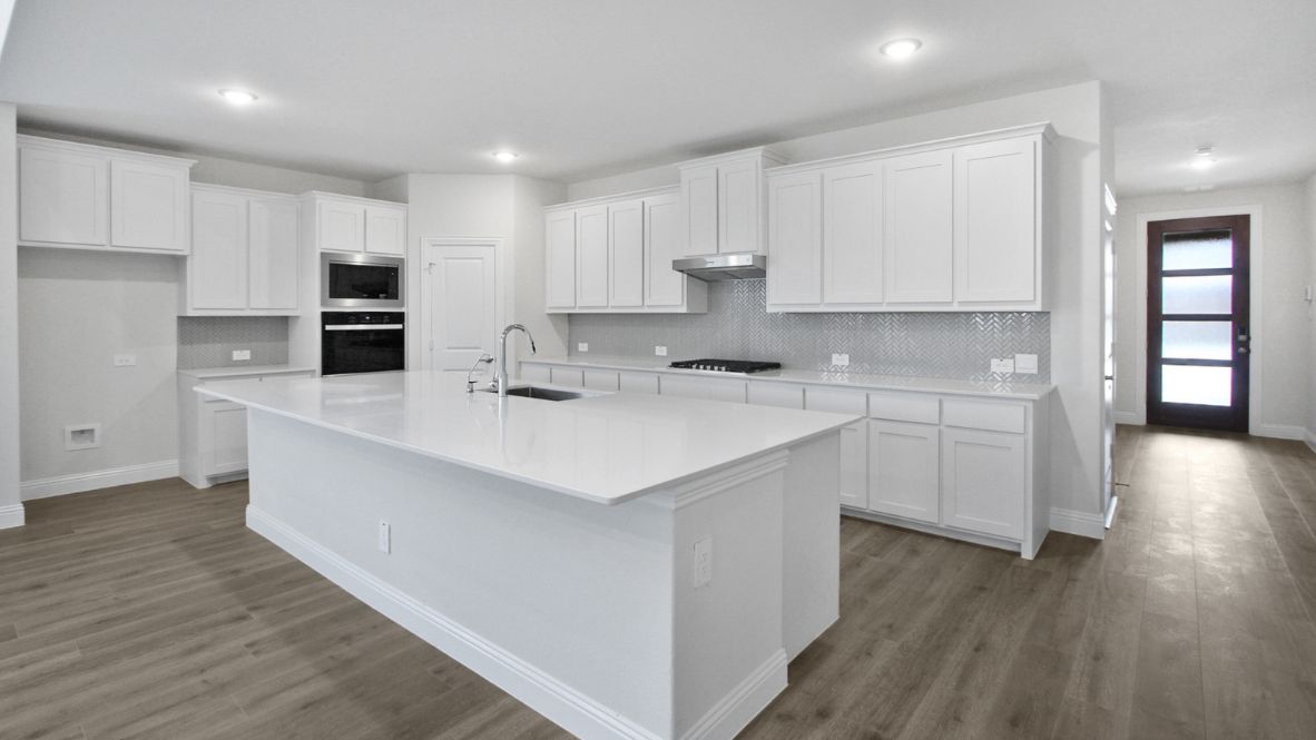 Bright and spacious kitchen with granite countertops, stainless steel appliances, and an island with bar seating.