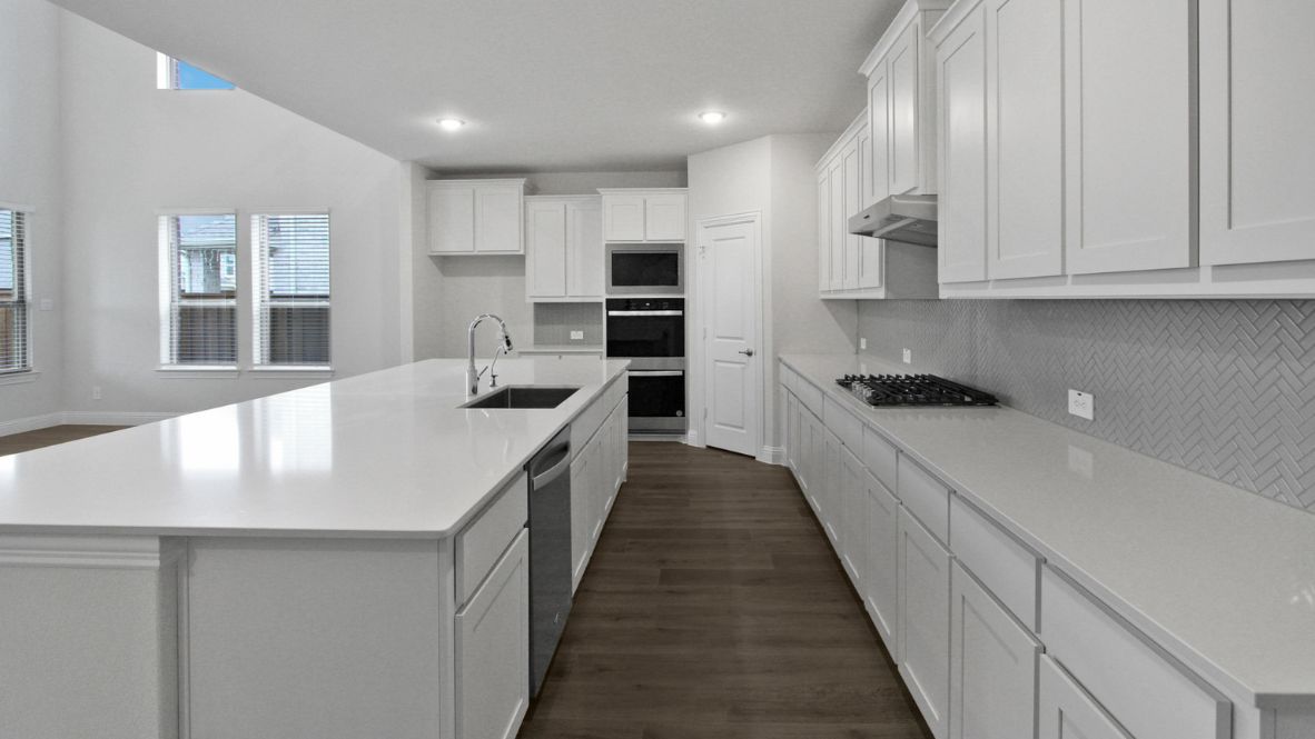 Bright and spacious kitchen with granite countertops, stainless steel appliances, and an island with bar seating.