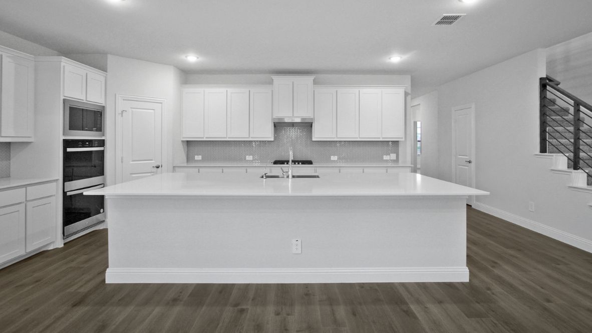 Bright and spacious kitchen with granite countertops, stainless steel appliances, and an island with bar seating.