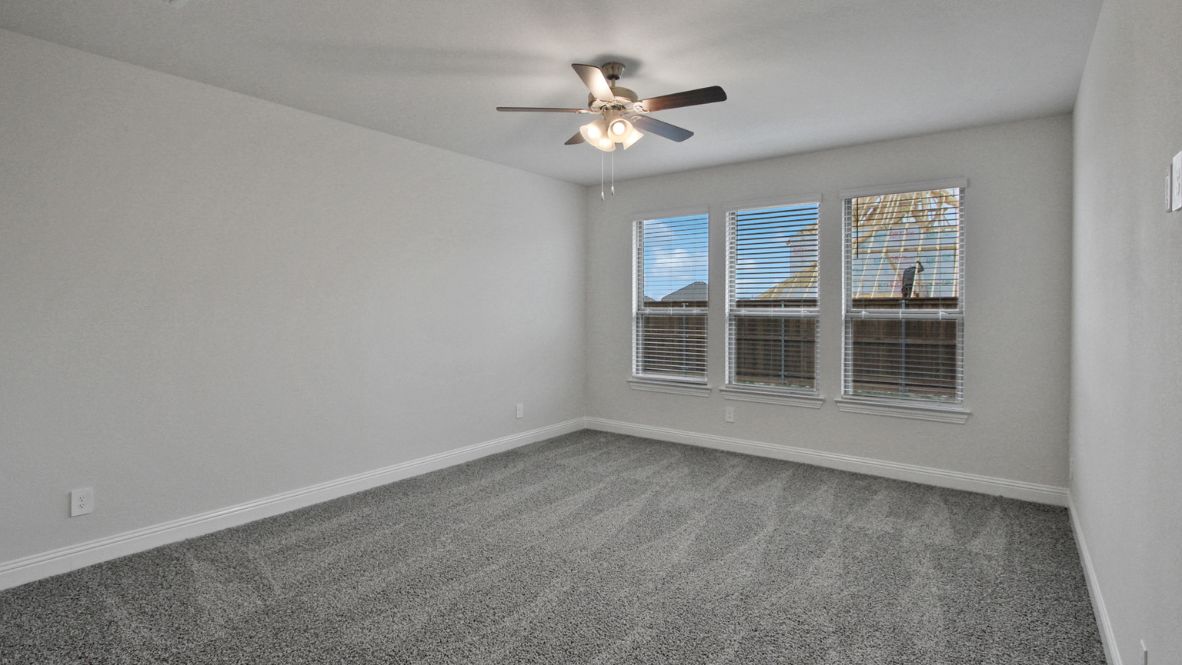 A spacious primary bedroom emphasizing open space and natural lighting.