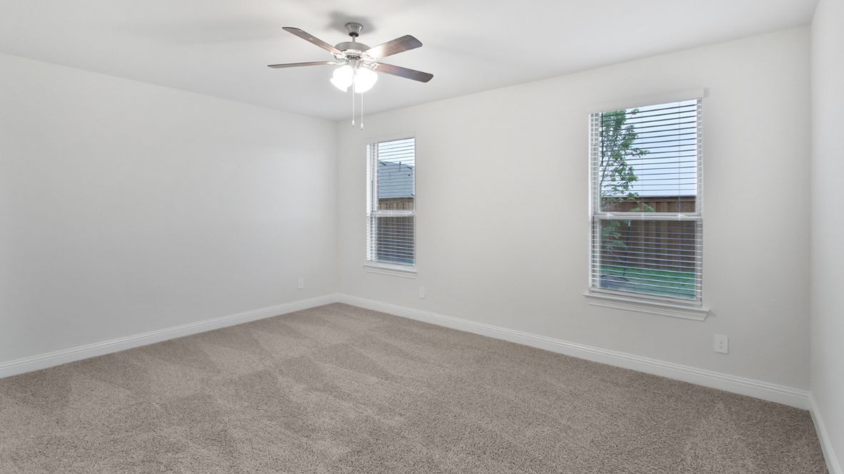 A spacious primary bedroom emphasizing open space and natural lighting.
