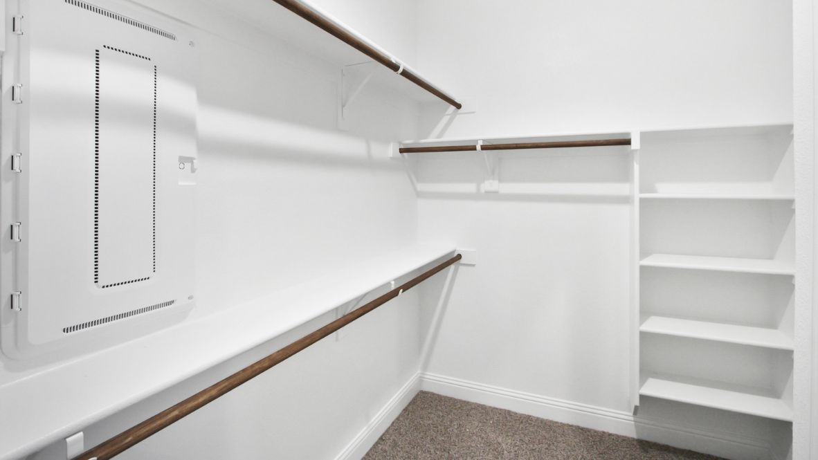 Spacious modern bathroom featuring a glass-enclosed shower, a large soaking tub with tiled surround and dual-sink vanity with sleek countertop. The layout includes a private water closet and a walk-in closet for added convenience, with natural light streaming through the window.