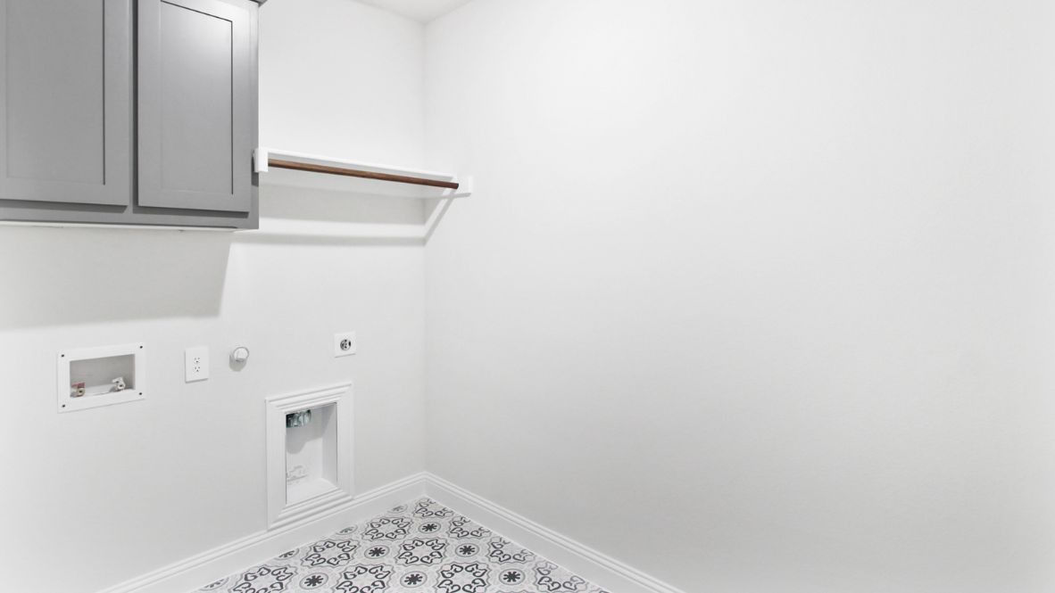 A laundry room featuring a washer and dryer, neatly arranged with ample space for laundry tasks and storage.