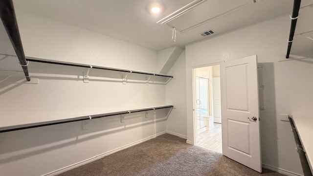 Large walk-in-closet with rods and shelves.