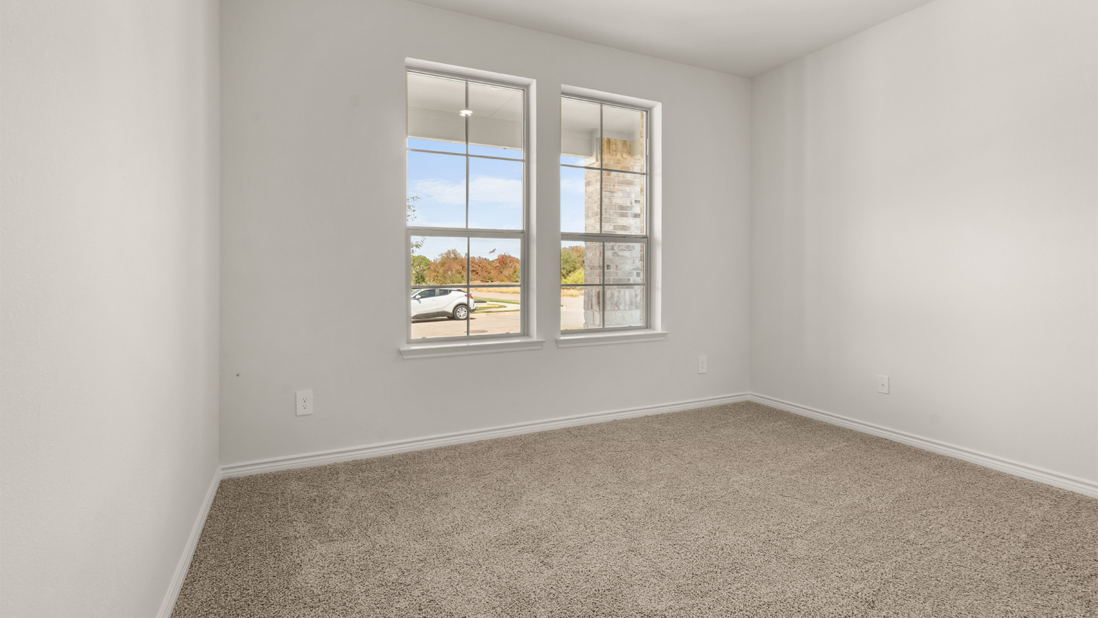 Primary bedroom with ceiling fan, plush carpeting, and a large walk-in closet.