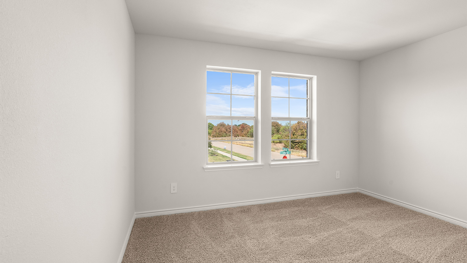 Primary bedroom with ceiling fan, plush carpeting, and a large walk-in closet.