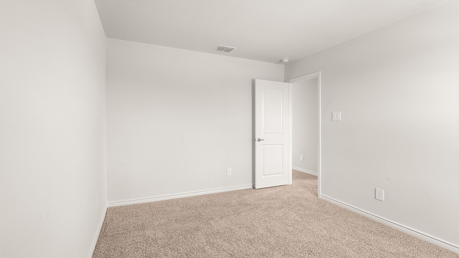 Primary bedroom with ceiling fan, plush carpeting, and a large walk-in closet.