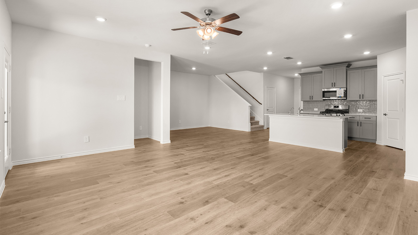 Formal dining room with large windows, vinyl wood floors, and view of the backyard.  Spacious dining area with vinyl wood flooring, large window and tall ceiling.