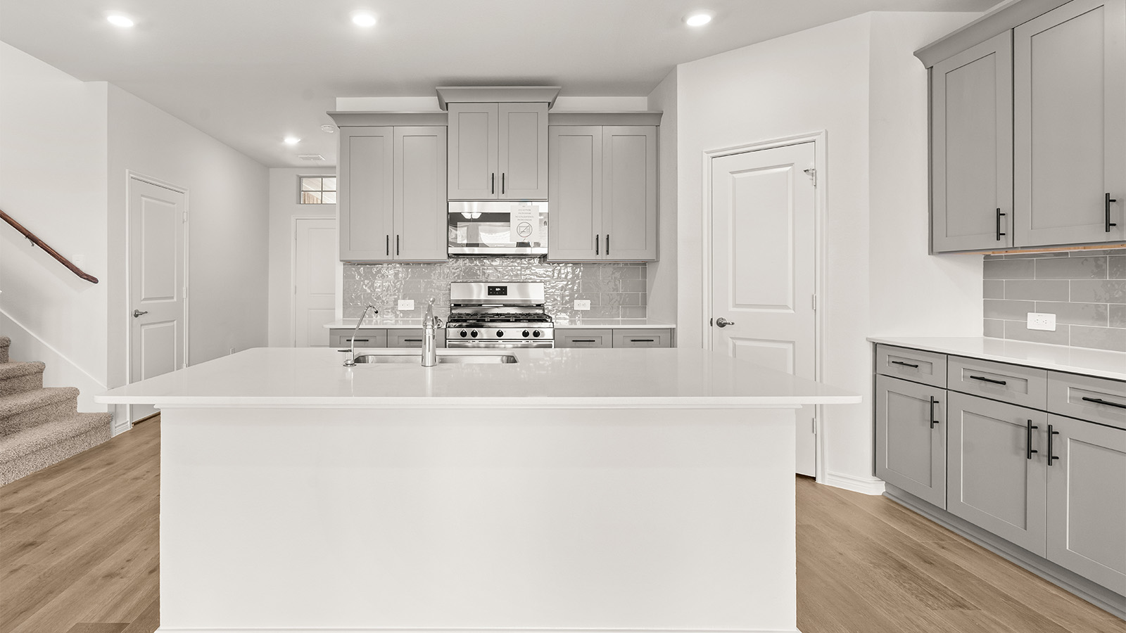 Bright and spacious kitchen with granite countertops, stainless steel appliances, and an island with bar seating.