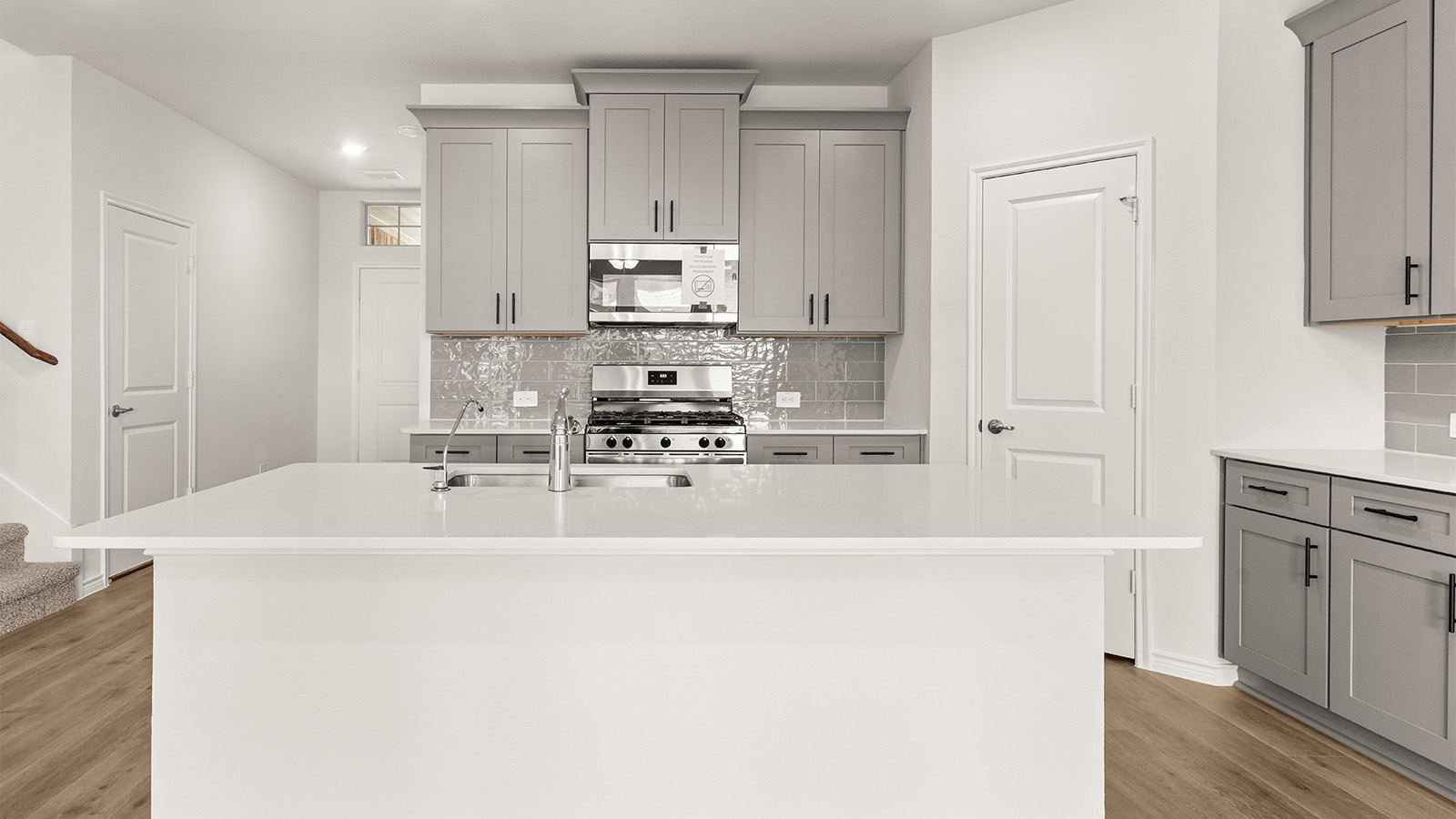 Bright and spacious kitchen with granite countertops, stainless steel appliances, and an island with bar seating.