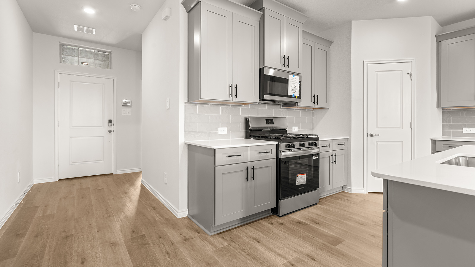 Bright and spacious kitchen with granite countertops, stainless steel appliances, and an island with bar seating.