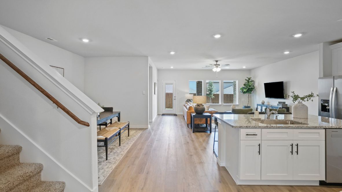 Contemporary kitchen adorned with white cabinets seamlessly integrated into an open dining area layout.
