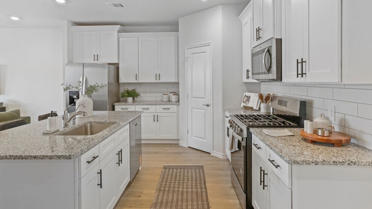 Contemporary kitchen adorned with white cabinets seamlessly integrated into an open dining area layout.