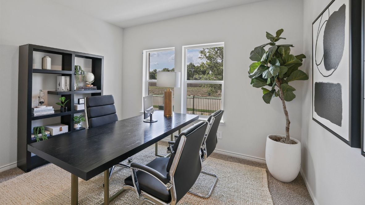 A tidy office featuring a desk, chair, and a window, creating a bright and organized workspace.