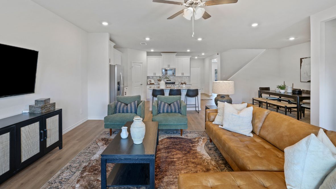 A well-organized living room that includes a kitchen and dining area, creating a warm and welcoming environment for gatherings.