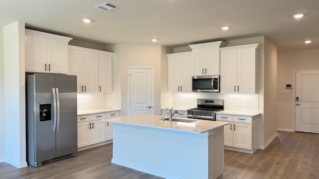 Bright and spacious kitchen with granite countertops, stainless steel appliances, and an island with bar seating.