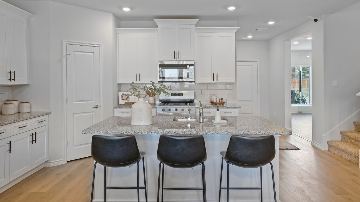 Bright and spacious kitchen with granite countertops, stainless steel appliances, and an island with bar seating.