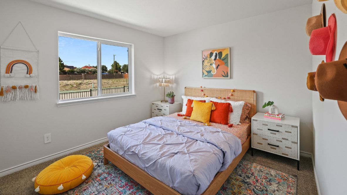 A vibrant kids' bedroom showcasing a neatly made bed, a stylish dresser, and a playful painting that adds charm.