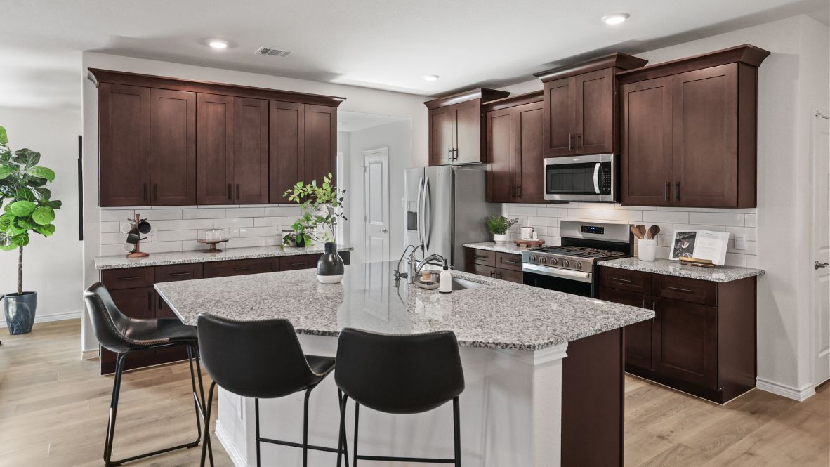 Bright and spacious kitchen with granite countertops, stainless steel appliances, and an island with bar seating.