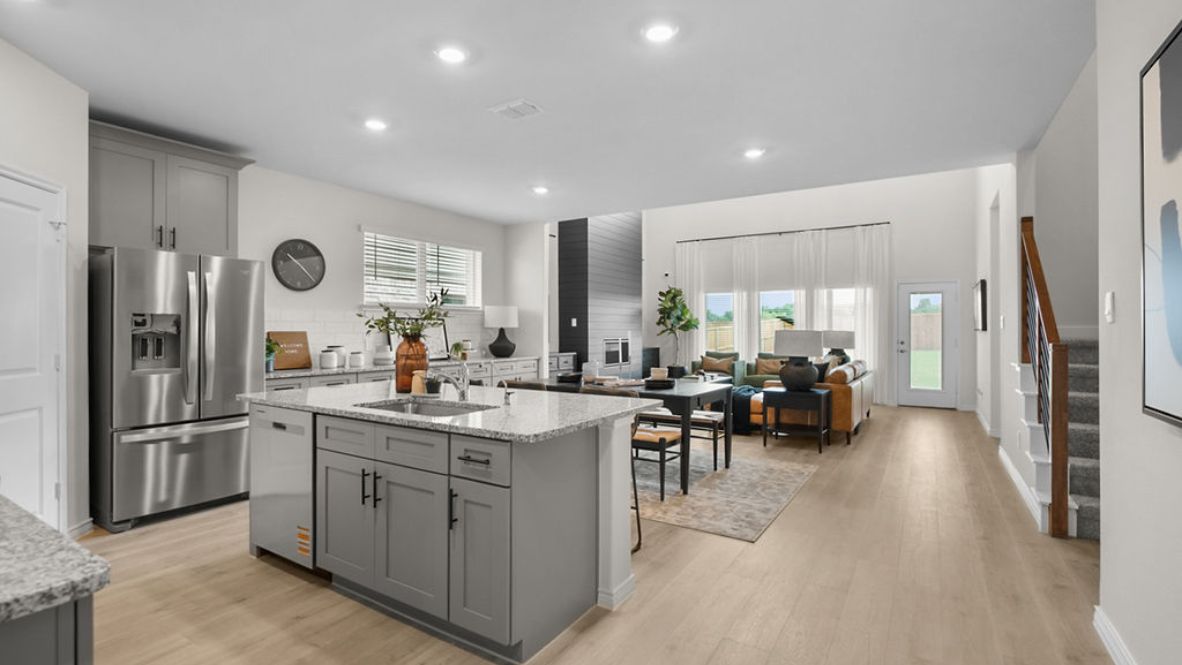 Bright and spacious kitchen with granite countertops, stainless steel appliances, and an island with bar seating.