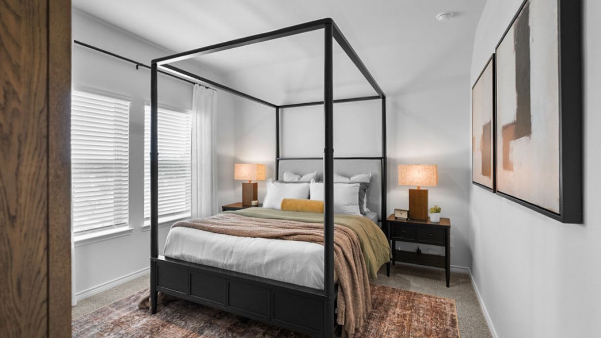 Comfortable guest bedroom featuring neutral-toned walls, carpeted flooring, and a nice window.