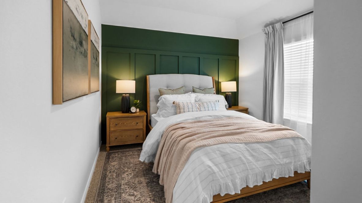 Modern primary bedroom with double nightstands, a large window and painting on the wall.