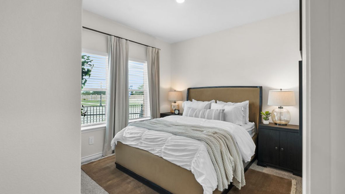 Secondary bedroom with dual vanities and two bedroom windows