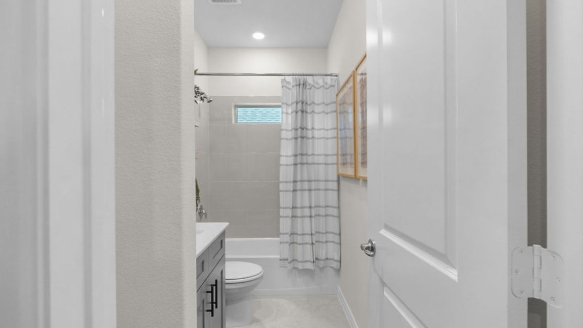 A well-designed bathroom equipped with granite countertops and marble shower tile, emphasizing functionality and contemporary style.