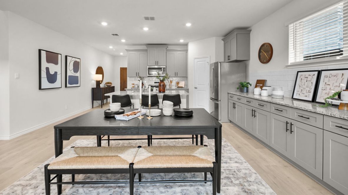 Contemporary kitchen adorned with grey cabinets seamlessly integrated into an open dining area layout.