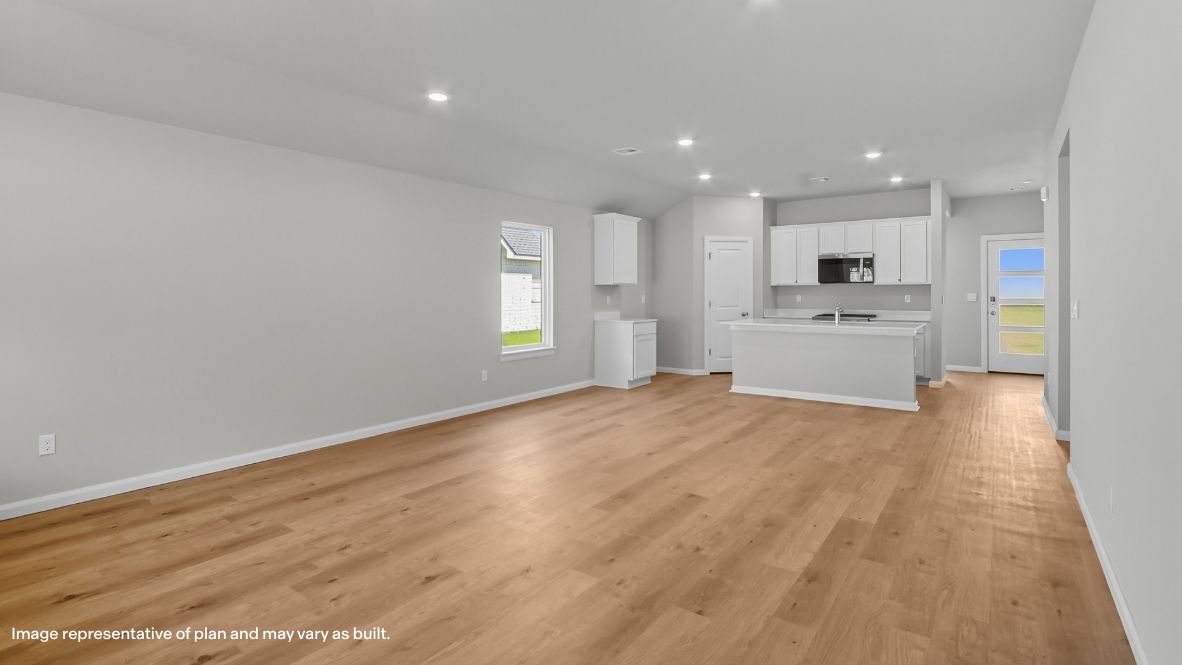 A well-organized living room that includes a kitchen and dining area, creating a warm and welcoming environment for gatherings.