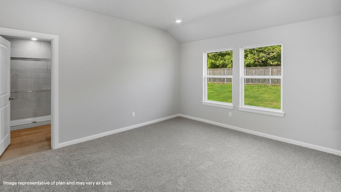 Primary bedroom with ceiling fan, plush carpeting, and a large walk-in closet.