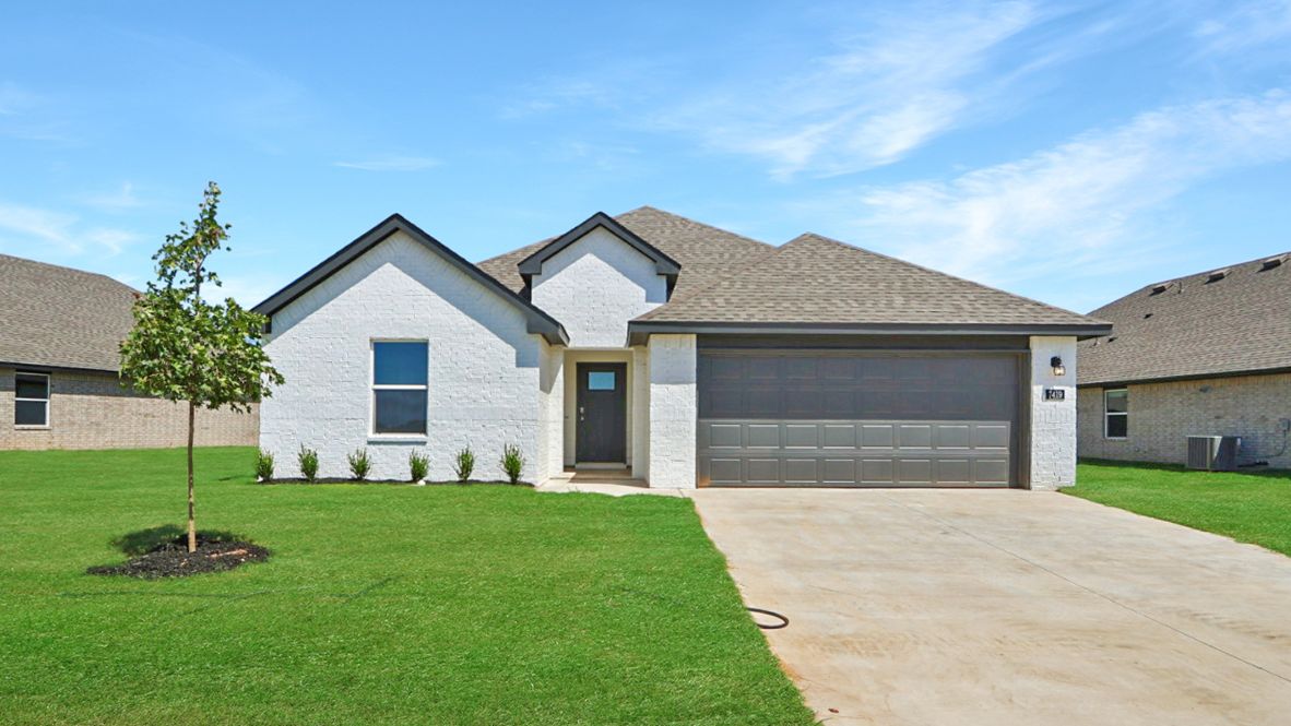 Front exterior in light white showcasing entryway, windows, and landscaped yard