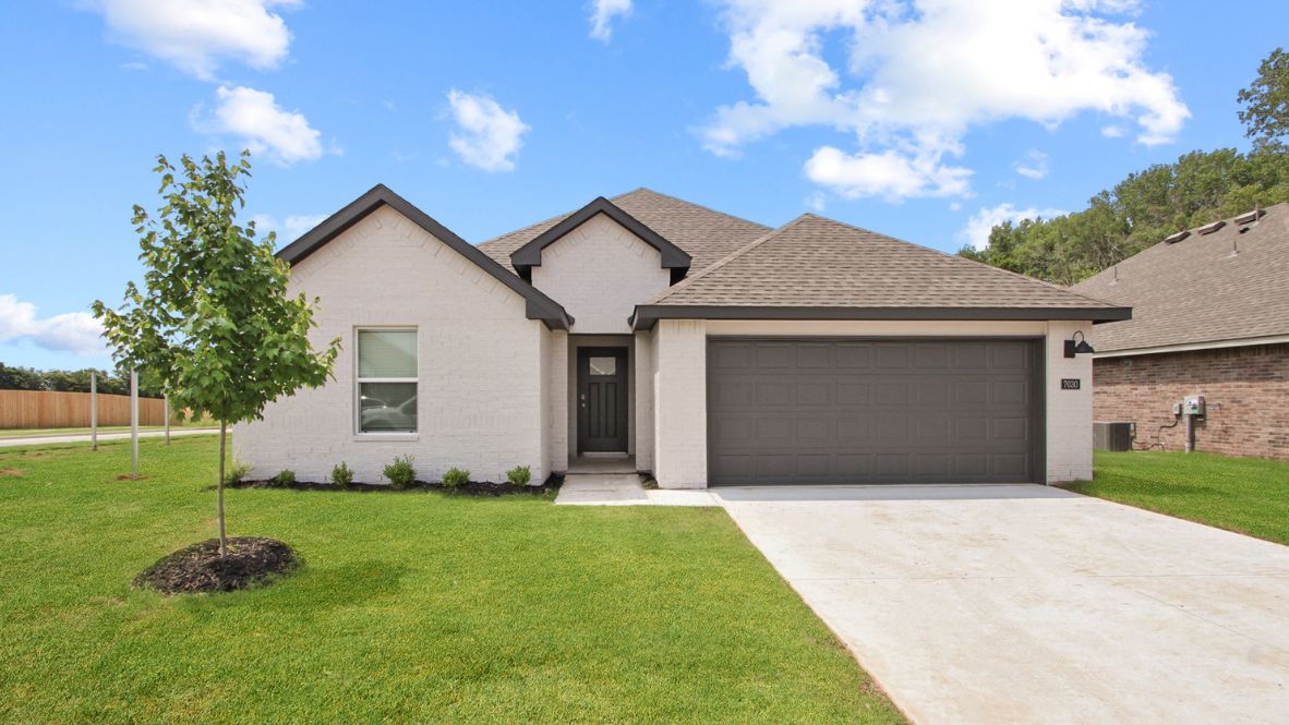 Exterior from sidewalk view of grass and front of new house