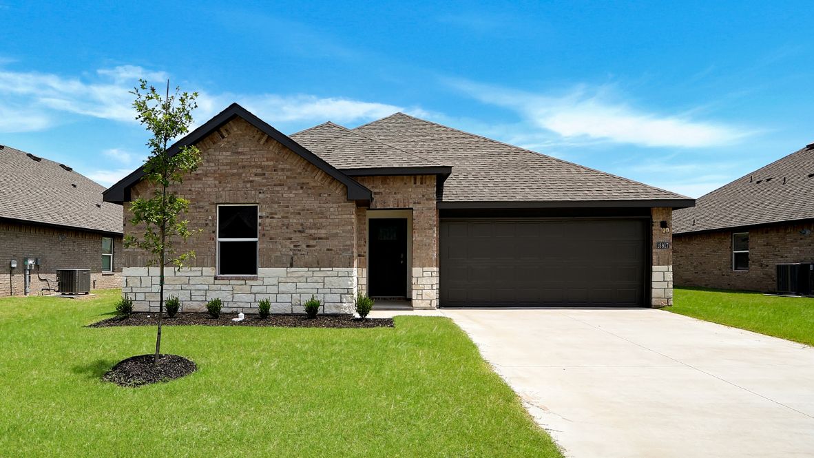Exterior from sidewalk view of grass and front of new house  Conrad Village